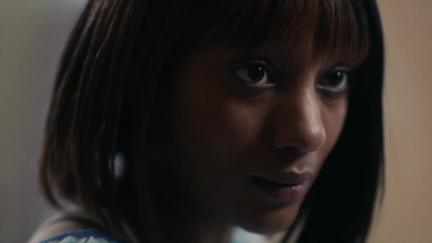 A sad looking black woman raises her head and looks up