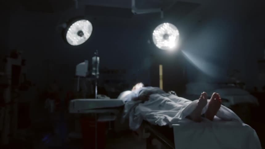 View of a hospital room with two large lights over a patient