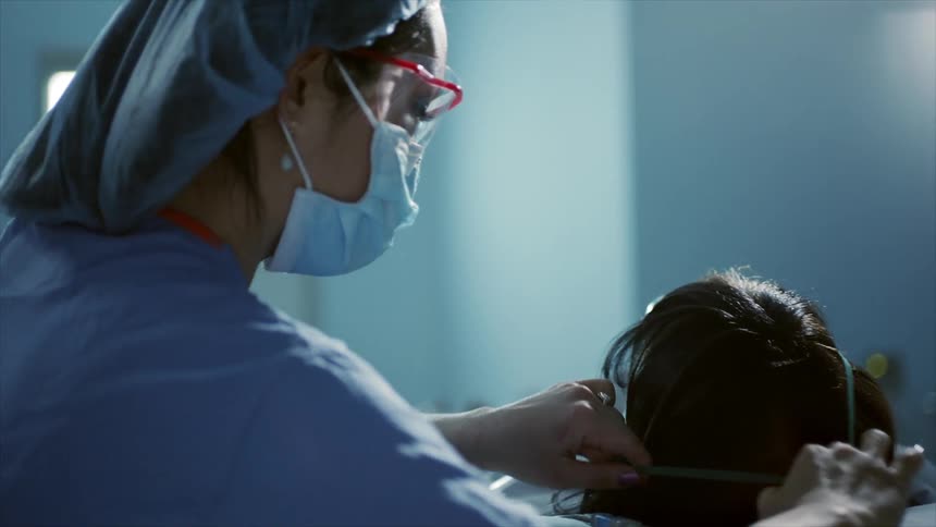 Nurse places an oxygen mask on a patient