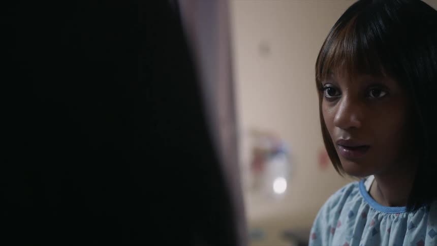 A woman in a hospital gown is talking to someone