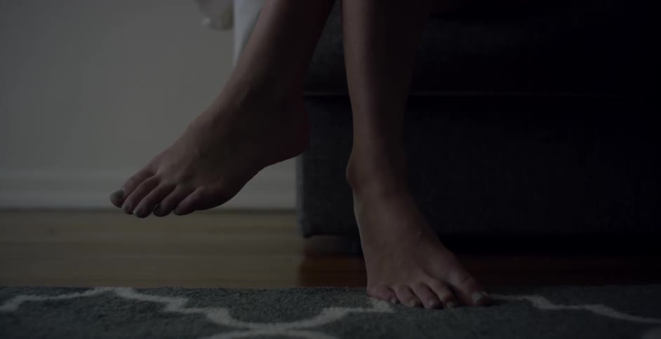 A view of two feet one on top of a carpet