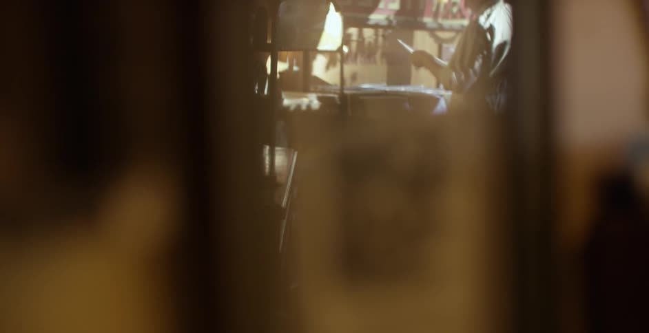 A person seen through a glass window looking at record albums