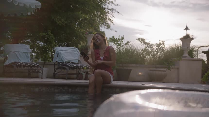 The woman laughs on the side of the pool