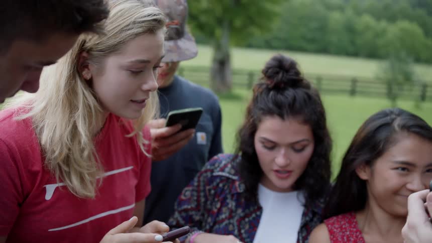 The group talk and look at their phones together
