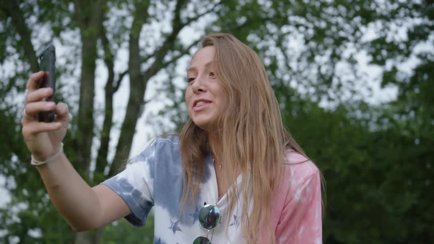 A girl laughs as she counts down to taking a photo with her phone