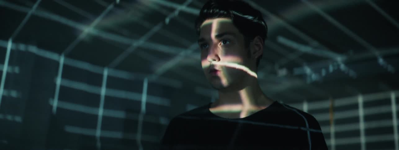 Man stands in a room that is covered with lines of light