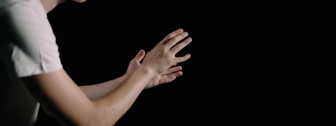 The man waves his fingers around and raises his hands