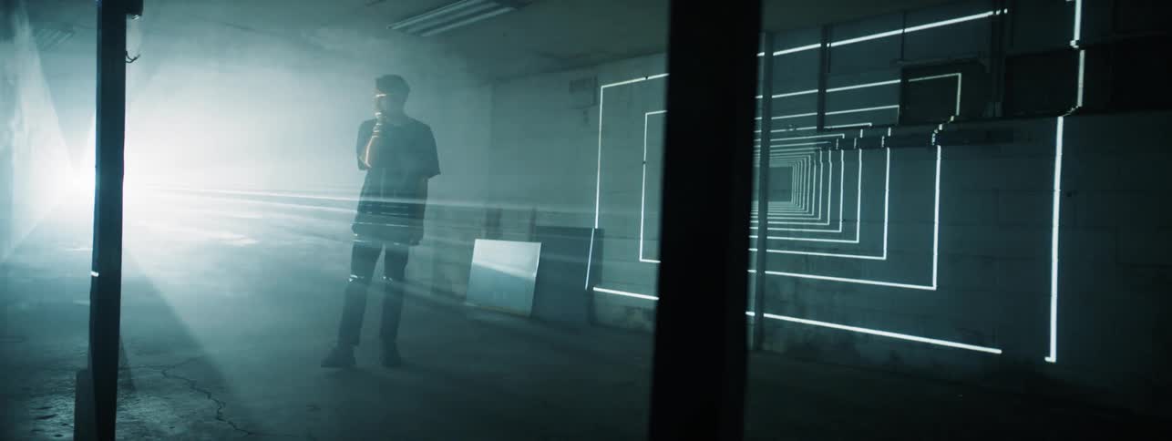 The man stands in the dark hall with flashing lights in square form