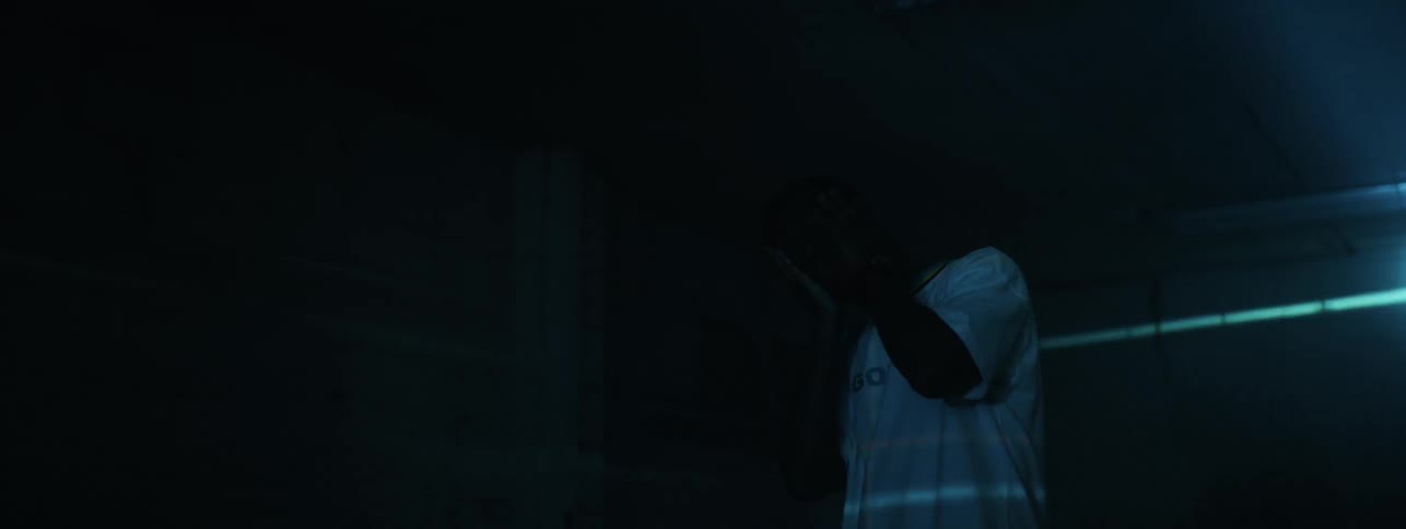 The man holds his hands to his face as the lights flash on him