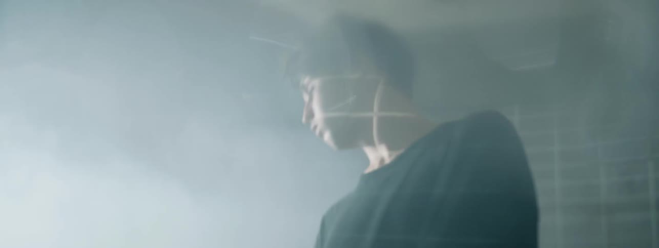 The man turns around then walks in the foggy room