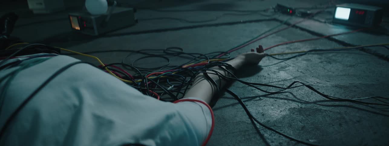 Man lays on the floor tangled up in wires