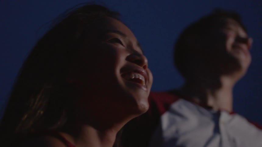 The man and woman smile watching the skyline at night