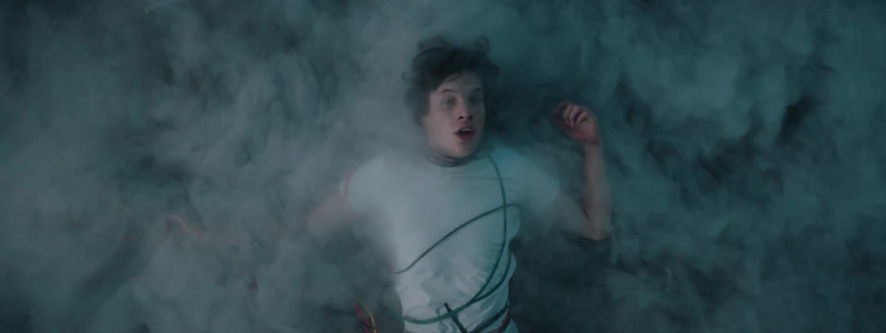 Man covered in wires and mist suddenly opens eyes