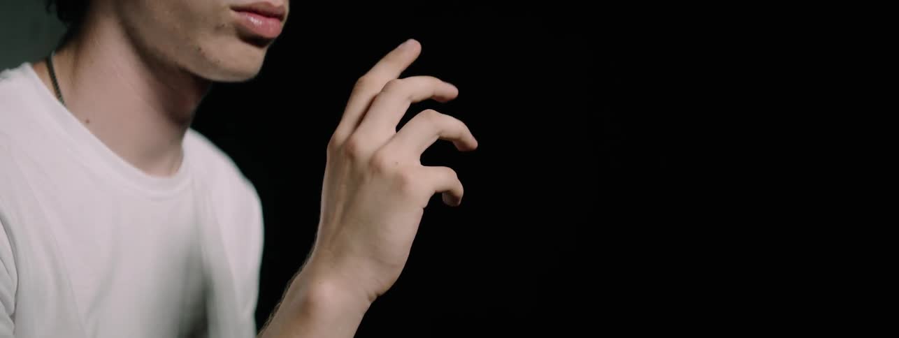 Man stares at his hand moving it around