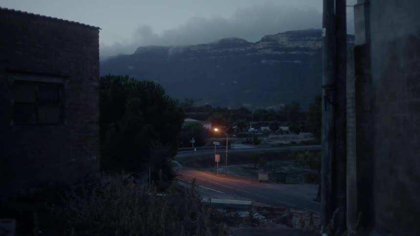 The car drives around the road in town at sunset