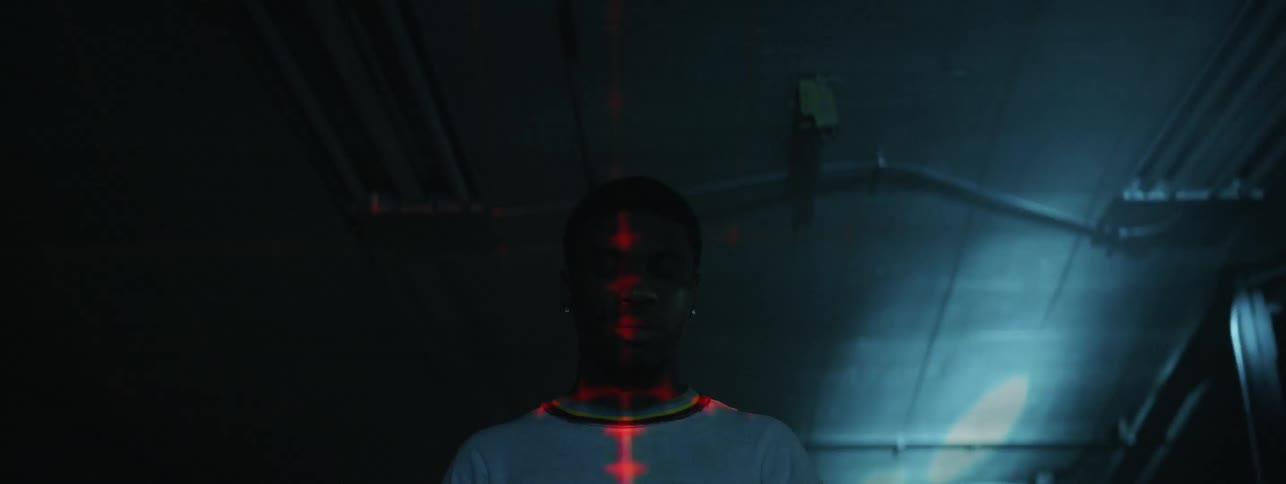 Lights flash around a man in a dark room
