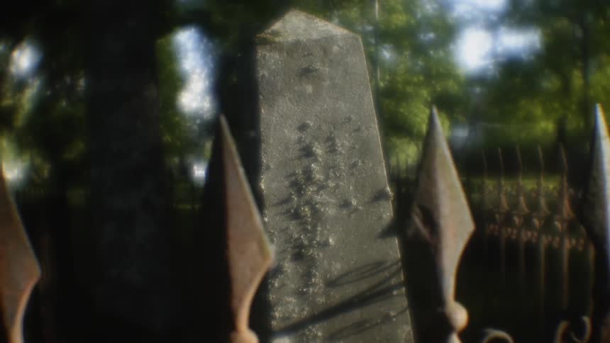 Cement structure sits surrounded by a fence with pointed tips