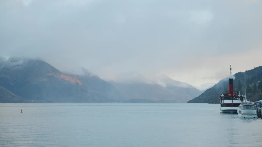 Clouds hang over the hill peaks and water