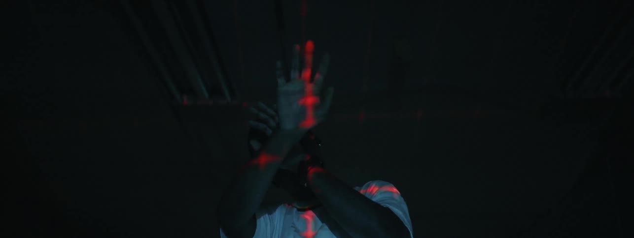 Man shields his eyes as a light flashes on him
