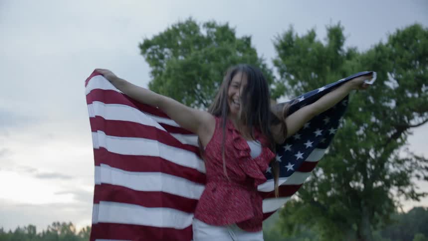 Woman wrapped in american flag dances