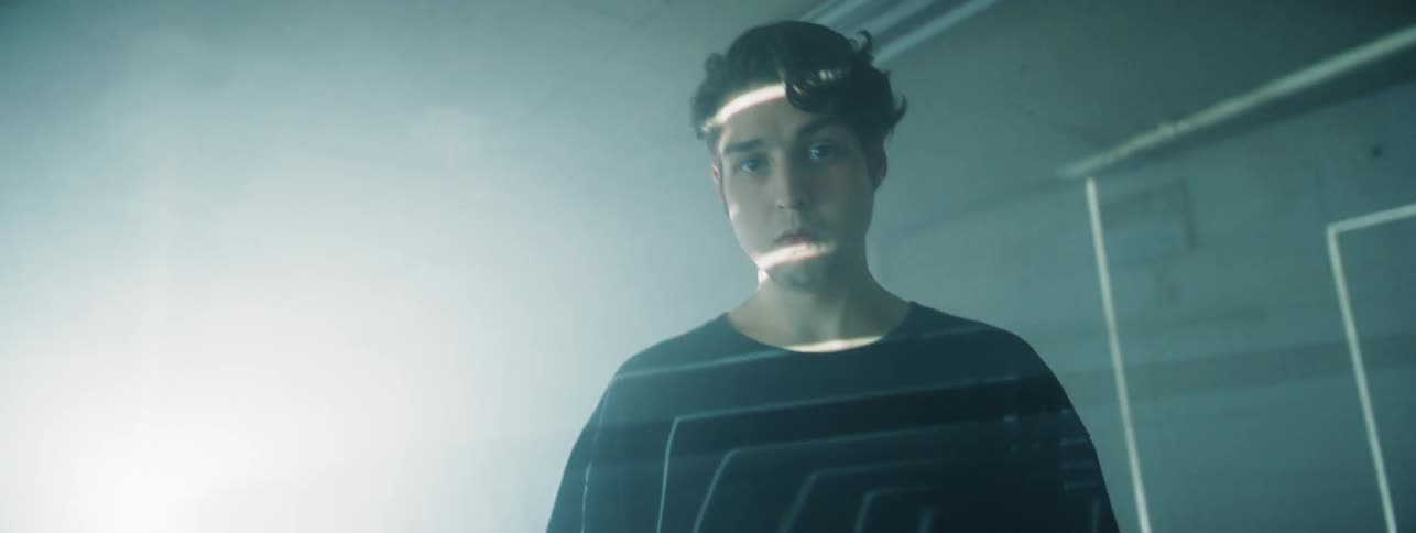 White lines and light are projected on a boy standing in a room