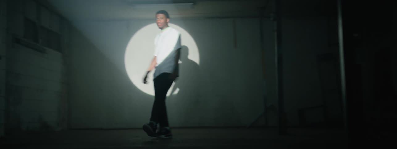 The man is dancing around in the spotlight