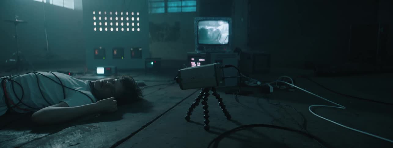 The man is knocked out on the ground with a camera pointing at him