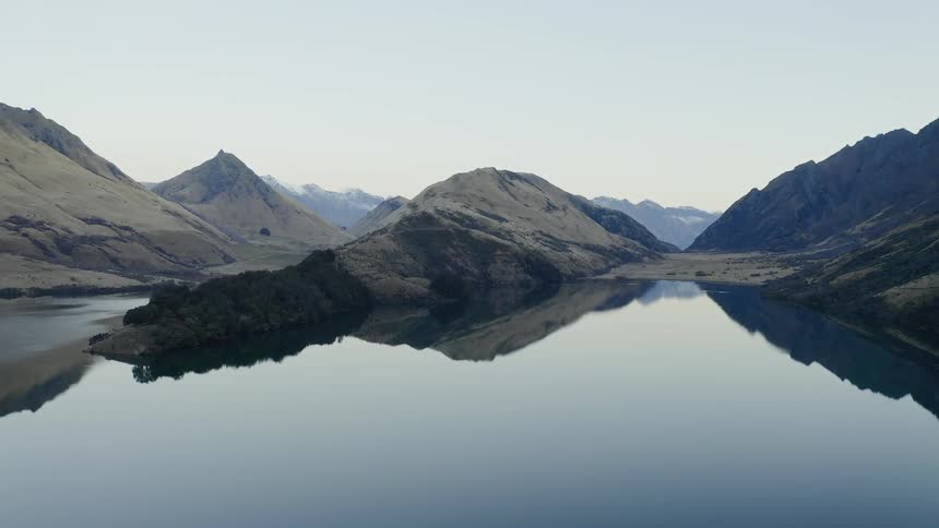 Mountains are reflecting off still lake water in the wilderness