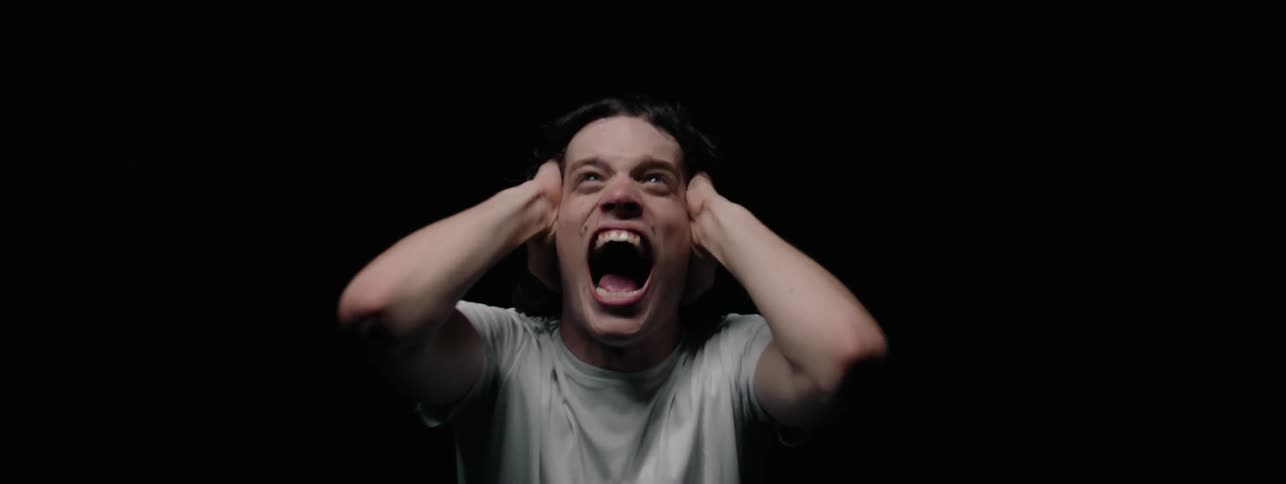 Man stands in darkness and screams