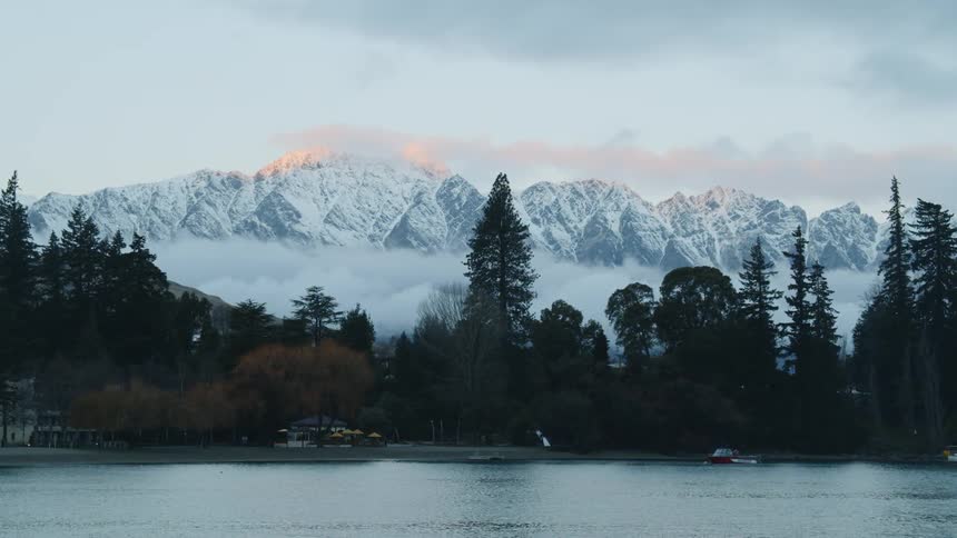 The trees line the lake before the mountains