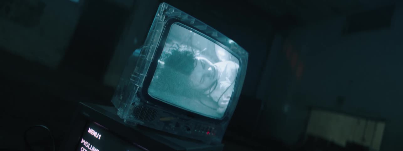 The small television is displaying an image in the dark