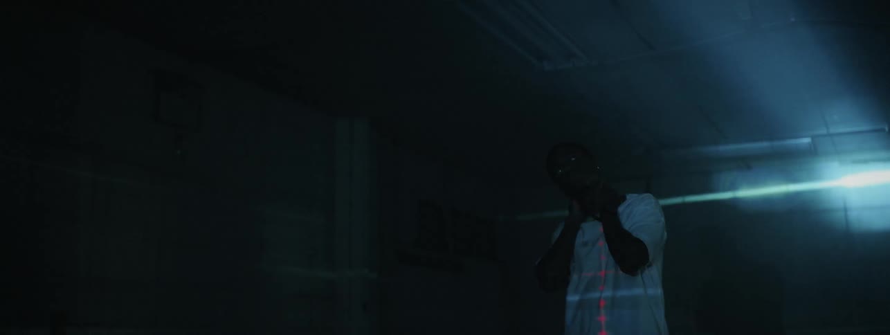 The man holds his neck in the room with flashing lights