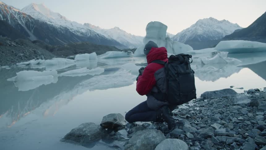 A photographer takes pictures of a frozen lake