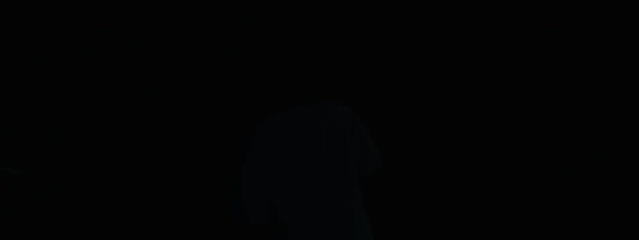 The man is standing in a room with blinking lights