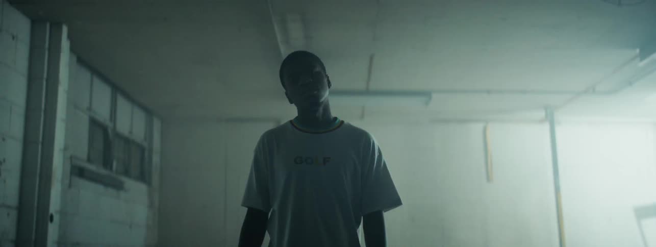 The man stands still in the dark room with a flashing light