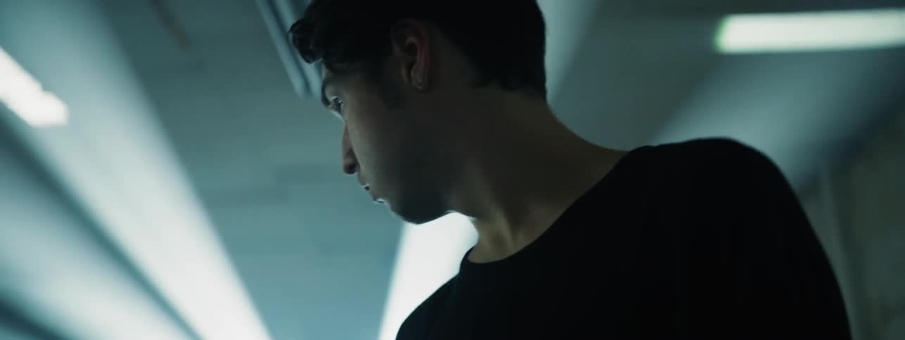 Lights flash around a man in a dark room