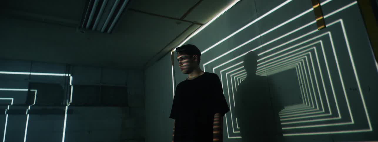 Lights flash around a man in a dark room