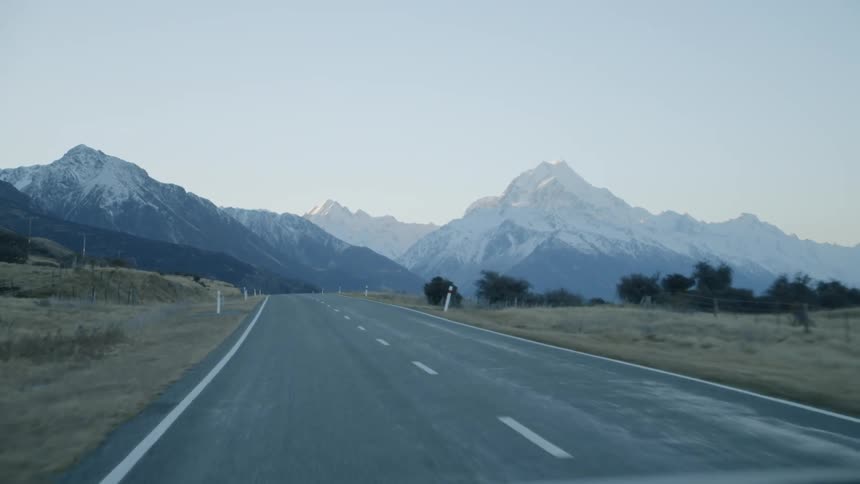 Vehicle travels down the highway towards the mountains