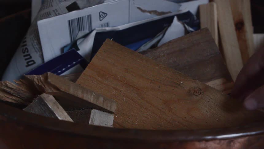 Person is removing wood kindling from pile