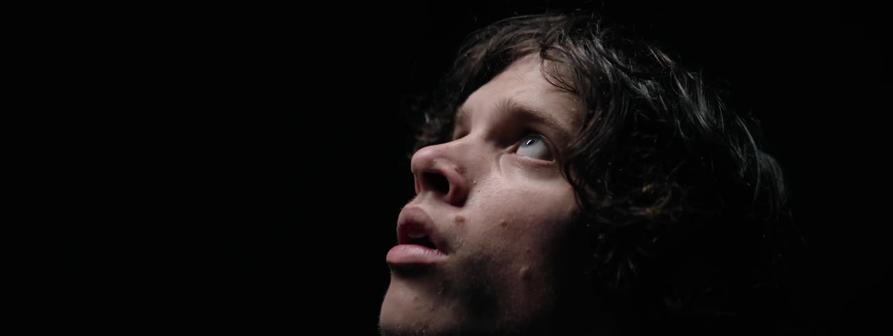 Man is standing in darkness and looking upward