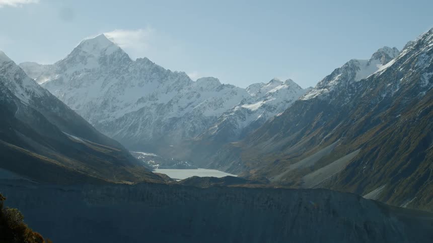 The cloud lingers on the top of the snowy mountain in the daytime