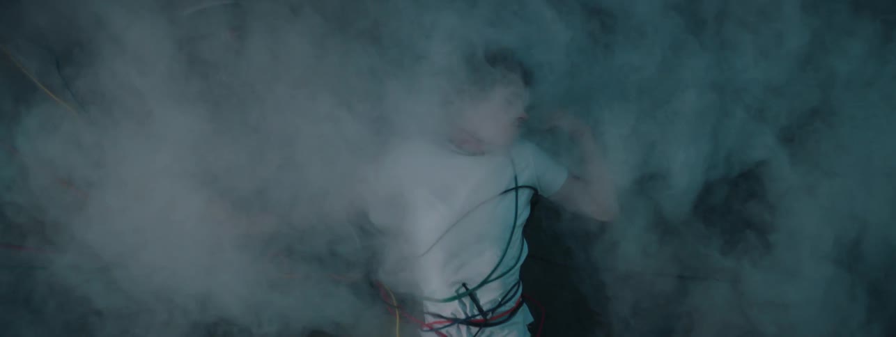 The fog rolls over the man covered in wires as he wakes