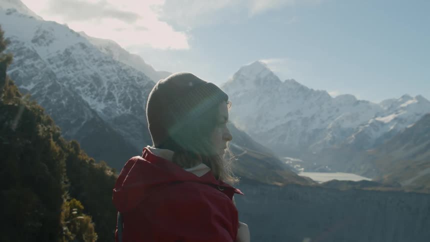Woman is observing scenery in snowy mountain wilderness