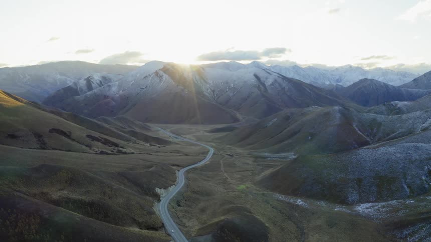 The sun shines over snowy mountains in the wilderness