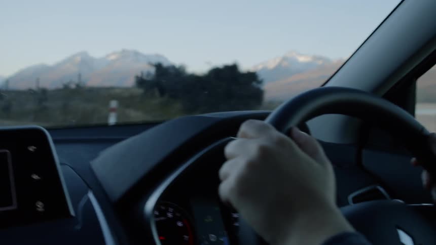 Person is driving in car on mountain highway