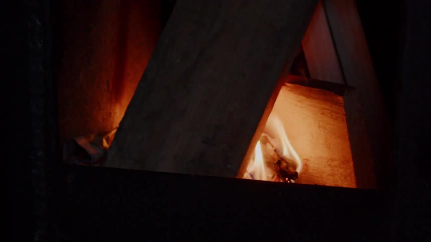 Flames are flickering on a board in a fire at night