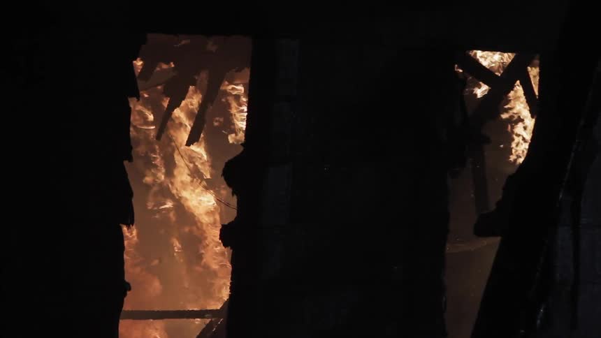 A house is on fire at night