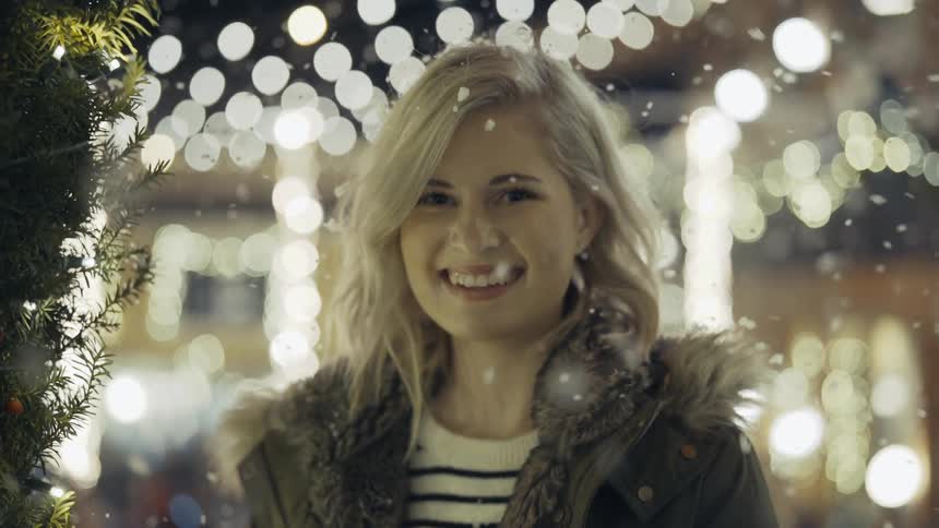 Snow gently falling down on a smiling woman