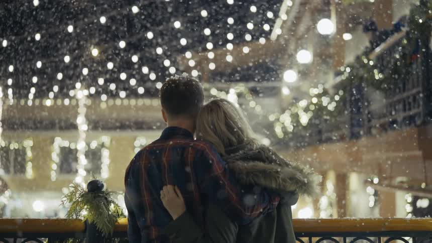A couple stand outside in the snow