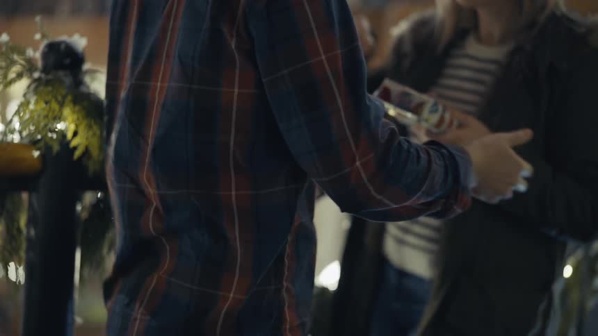 A man presents a woman with a wrapped gift during the holidays